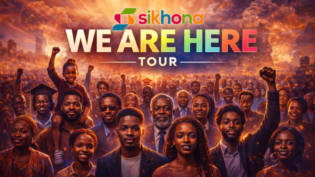 A group of attendees at the Sikhona “We Are Here” Tour event, gathered in a shared space with event branding visible in the background.
